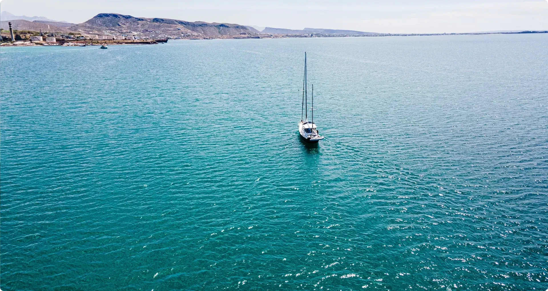 sailboat sailing towards paradisiac island
