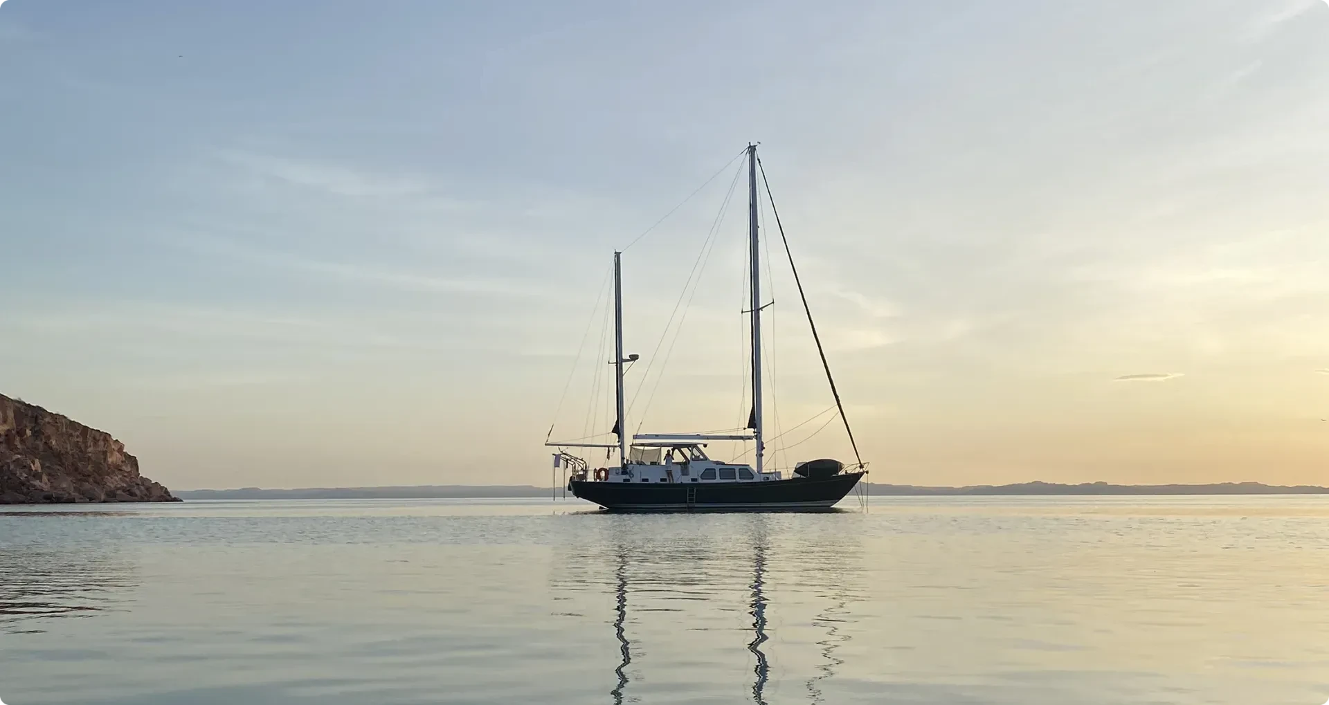 sailboat on calm waters at sunrise